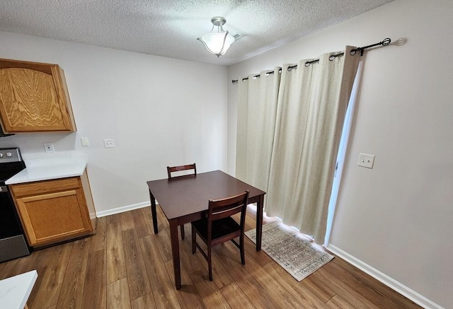 dining room with a textured ceiling and dark wood-type flooring