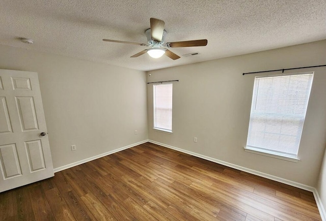 spare room featuring hardwood / wood-style flooring, ceiling fan, and a wealth of natural light