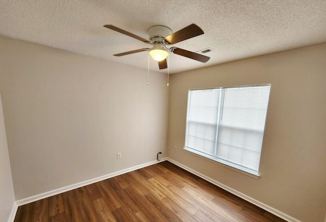 spare room featuring ceiling fan, wood-type flooring, and a textured ceiling