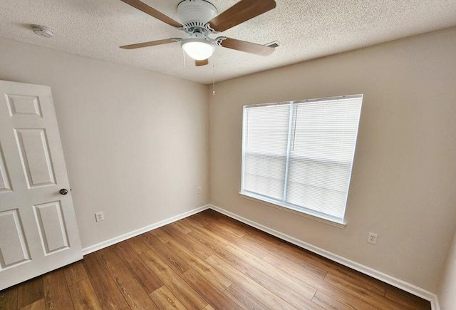 unfurnished room with a textured ceiling, light hardwood / wood-style floors, and ceiling fan