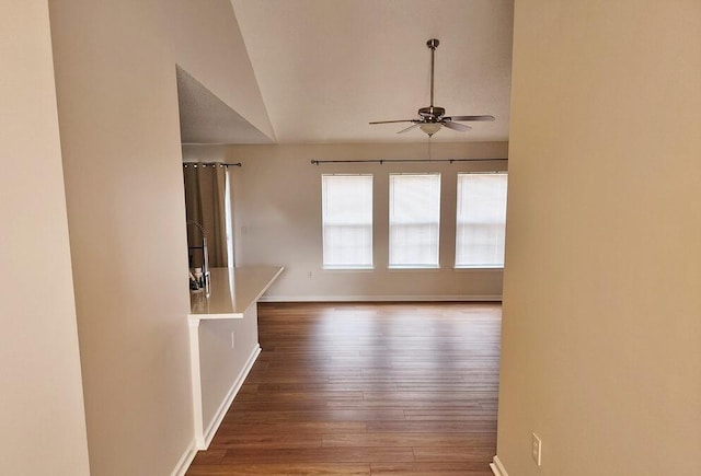 spare room featuring hardwood / wood-style floors, vaulted ceiling, and ceiling fan