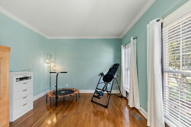 sitting room featuring ornamental molding and wood-type flooring