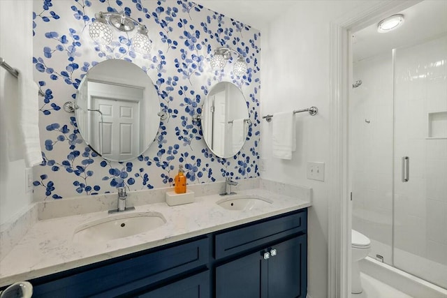 bathroom featuring toilet, vanity, and a shower with shower door