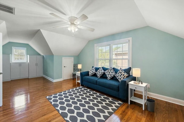 living room featuring lofted ceiling, wood-type flooring, and plenty of natural light