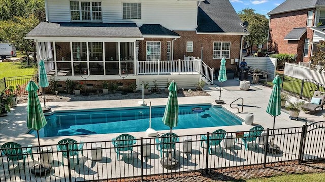 view of swimming pool featuring a sunroom and a patio