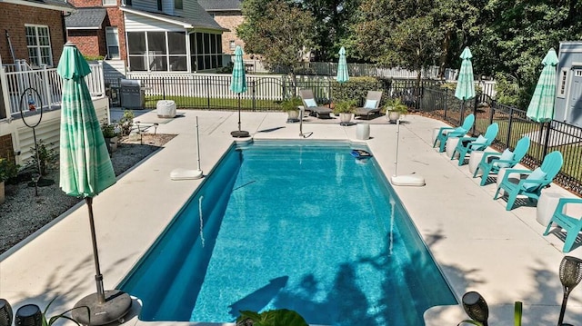 view of swimming pool with a grill, a sunroom, and a patio