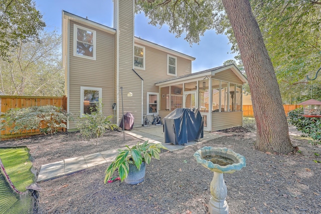 rear view of property featuring a patio and a sunroom