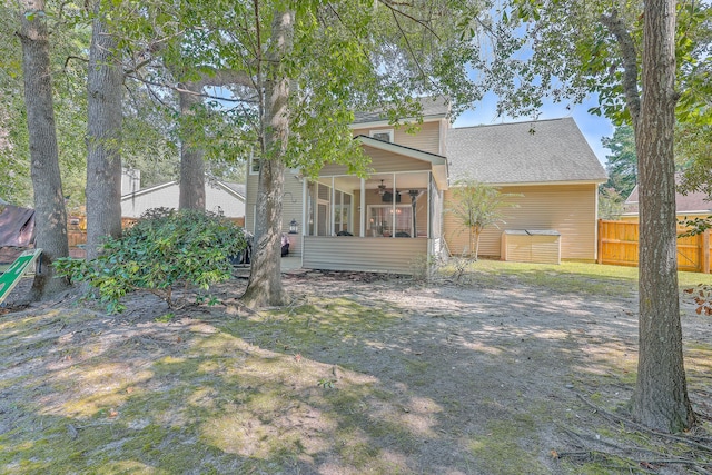 rear view of property with a sunroom and ceiling fan