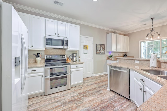 kitchen featuring sink, appliances with stainless steel finishes, white cabinetry, hanging light fixtures, and a chandelier