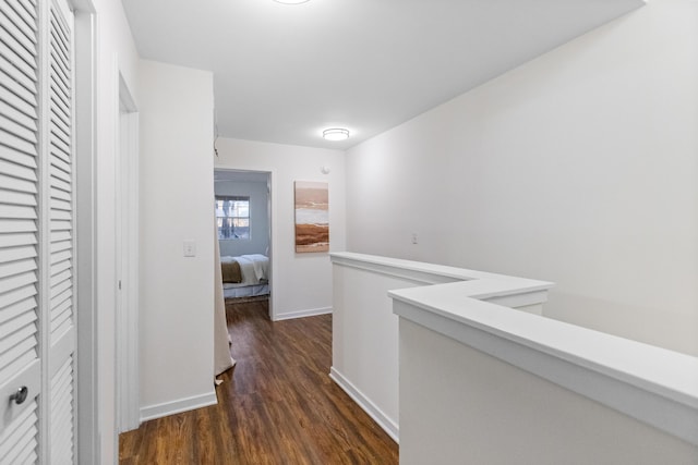 corridor with dark hardwood / wood-style flooring