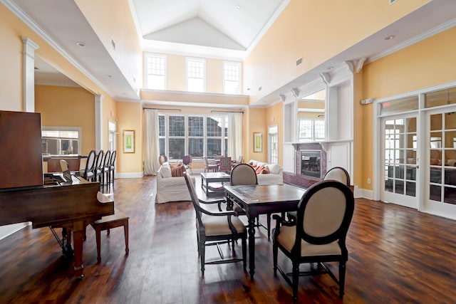 dining area featuring crown molding, a healthy amount of sunlight, high vaulted ceiling, and dark hardwood / wood-style flooring