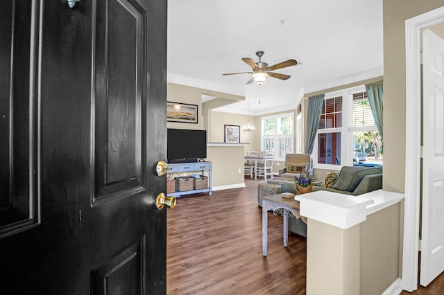 living room featuring crown molding, dark hardwood / wood-style flooring, and ceiling fan