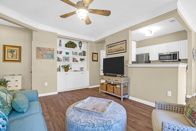 living room with ornamental molding, dark wood-type flooring, and ceiling fan