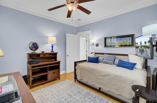 bedroom featuring ceiling fan, light hardwood / wood-style floors, and crown molding