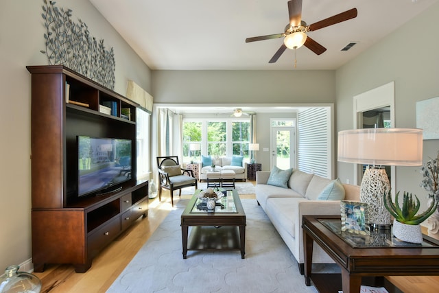 living room with ceiling fan and light hardwood / wood-style flooring