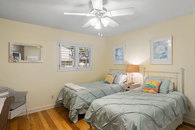 bedroom featuring wood-type flooring, a textured ceiling, and ceiling fan