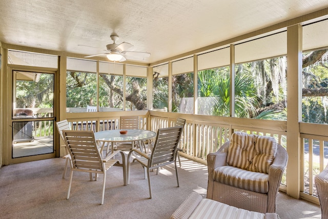 sunroom featuring ceiling fan and outdoor dining space