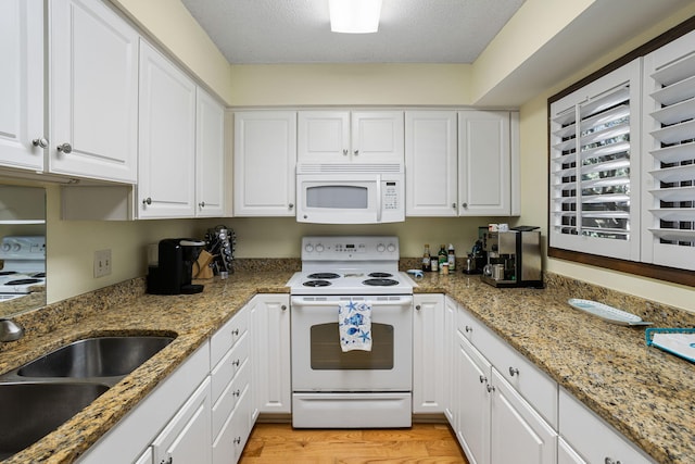 kitchen with white appliances, light hardwood / wood-style floors, sink, and white cabinetry