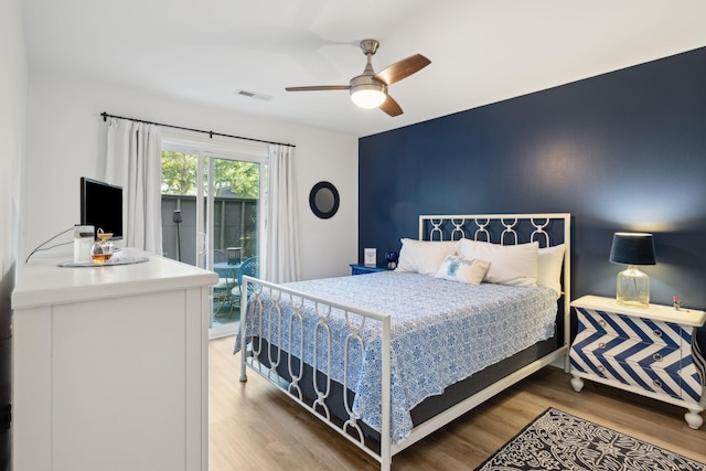 bedroom featuring hardwood / wood-style flooring, ceiling fan, and access to outside