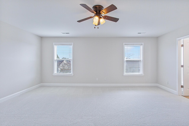 unfurnished room with ceiling fan, baseboards, and light colored carpet