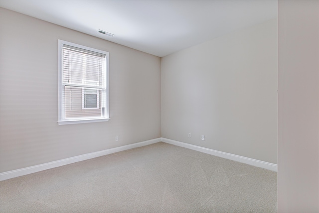 carpeted empty room with visible vents and baseboards