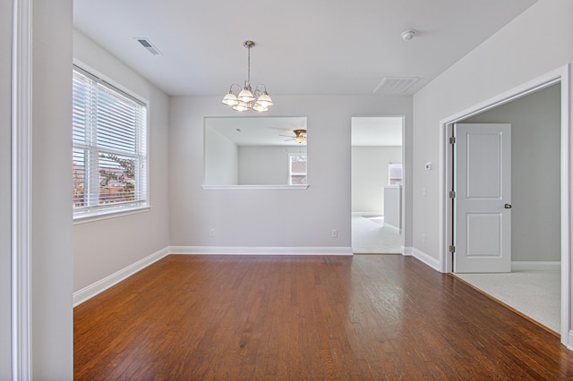 empty room with dark wood-style floors, baseboards, and visible vents