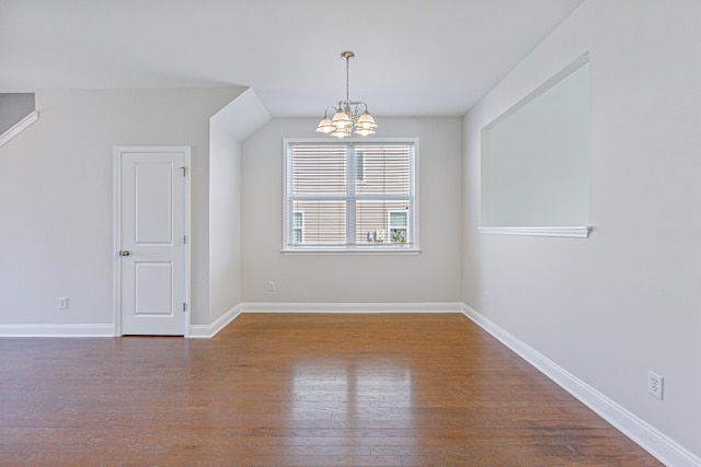 interior space with baseboards, a chandelier, and wood finished floors