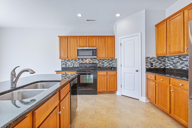 kitchen featuring stainless steel microwave, brown cabinetry, a sink, dishwasher, and black / electric stove