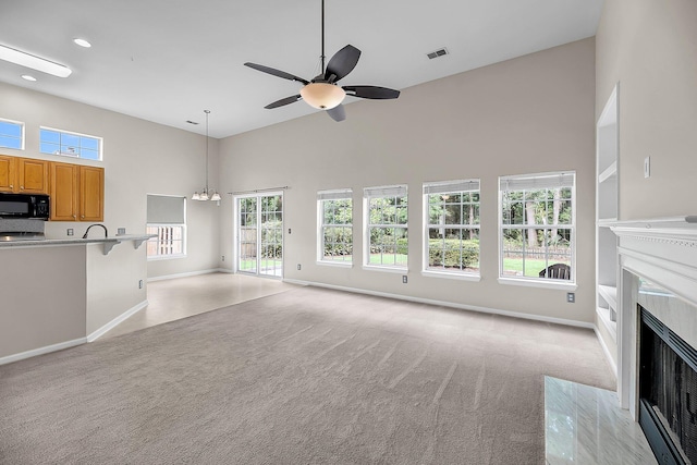 1445 Ashley Gardens Blvd, Charleston, SC 29414 - unfurnished living room featuring high vaulted ceiling, light carpet, baseboards, a high end fireplace, and recessed lighting