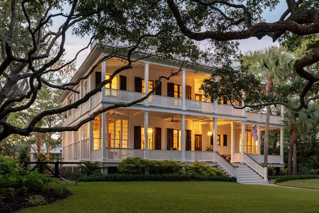 rear view of house featuring a lawn, ceiling fan, a balcony, and covered porch