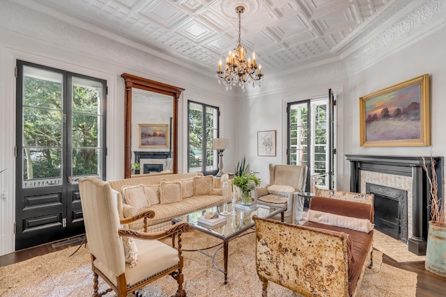 living room with hardwood / wood-style flooring, ornamental molding, coffered ceiling, and a notable chandelier