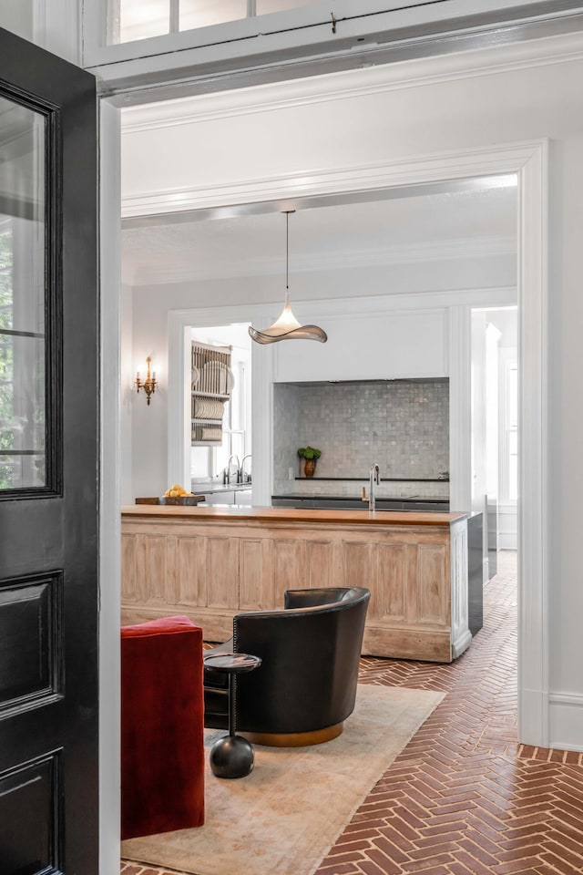 bar with light brown cabinets, pendant lighting, tasteful backsplash, and crown molding