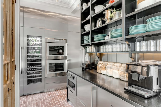 kitchen with crown molding, stainless steel appliances, and beverage cooler