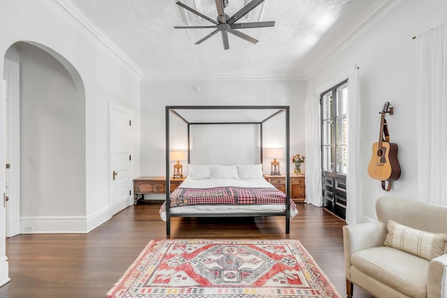 bedroom featuring dark hardwood / wood-style flooring, ceiling fan, and crown molding