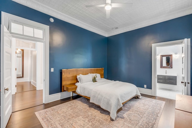 bedroom featuring hardwood / wood-style floors, ceiling fan, crown molding, and ensuite bathroom