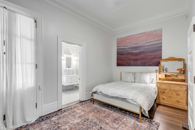 bedroom featuring hardwood / wood-style floors, ensuite bathroom, and crown molding