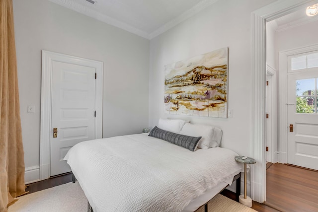 bedroom with wood-type flooring and ornamental molding