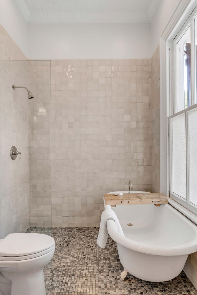 bathroom with tile patterned floors, crown molding, toilet, tile walls, and independent shower and bath