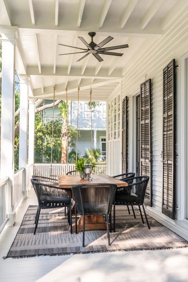 sunroom / solarium featuring beam ceiling and ceiling fan