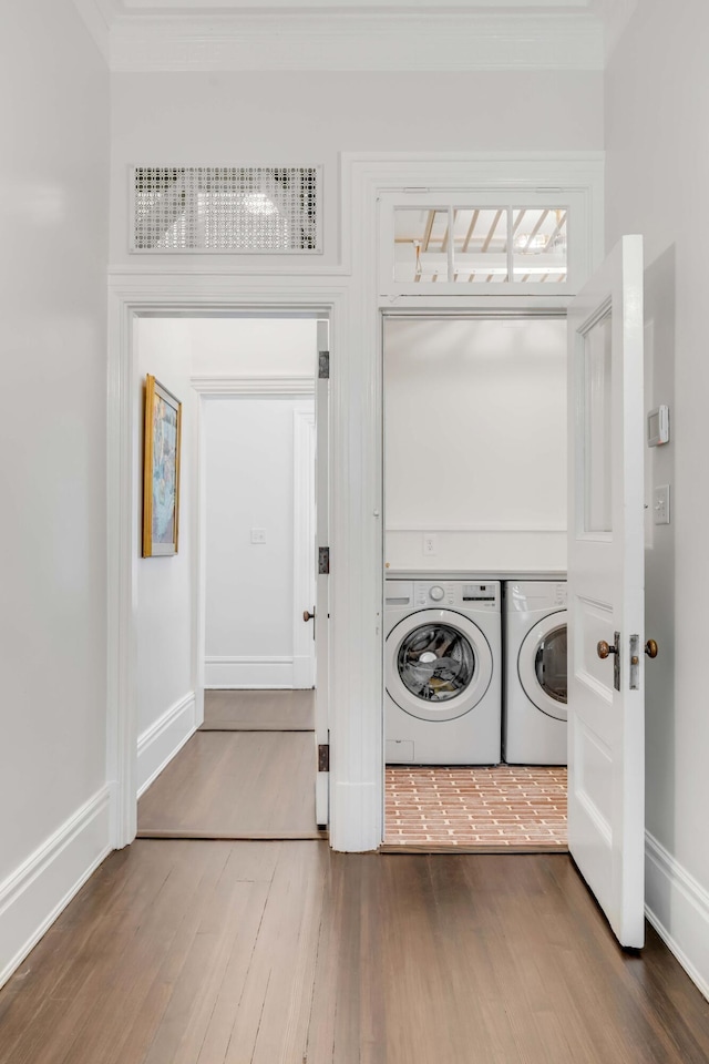 clothes washing area with hardwood / wood-style floors and independent washer and dryer