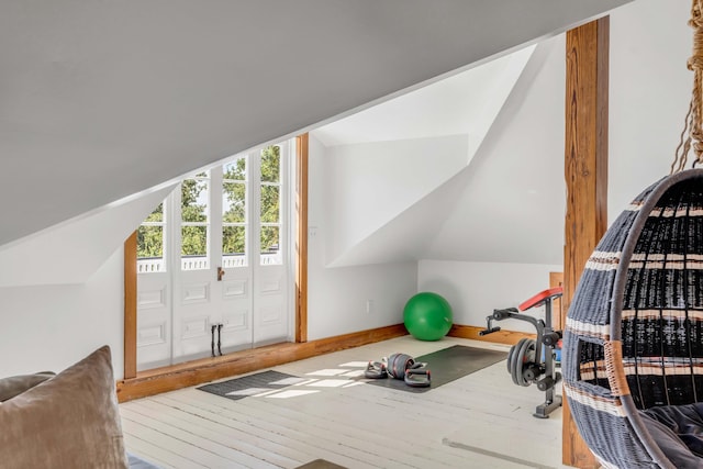 workout area with hardwood / wood-style floors and vaulted ceiling