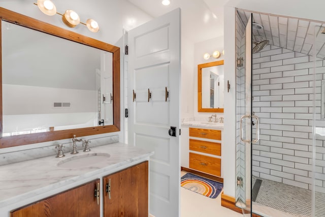 bathroom featuring tile patterned floors, vanity, a shower with shower door, and lofted ceiling