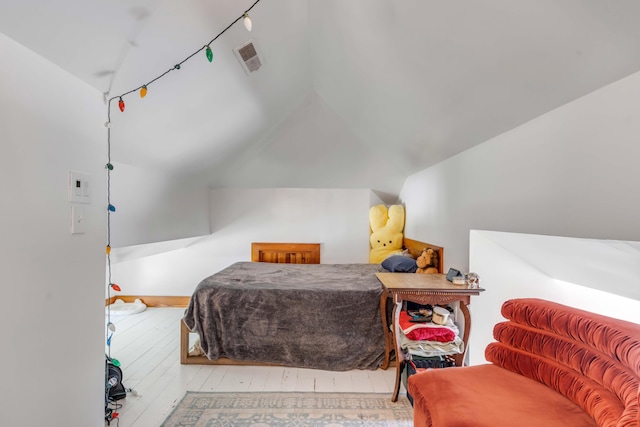 bedroom featuring light hardwood / wood-style floors and vaulted ceiling