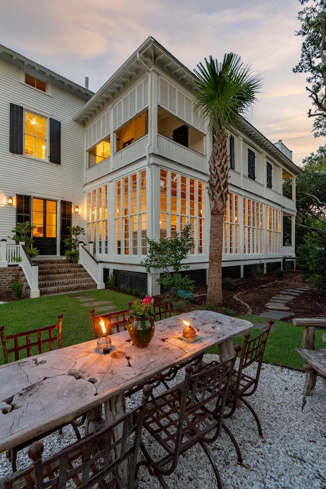 back house at dusk featuring a patio and an outdoor fire pit