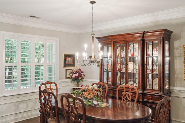 dining room with ornamental molding and a chandelier