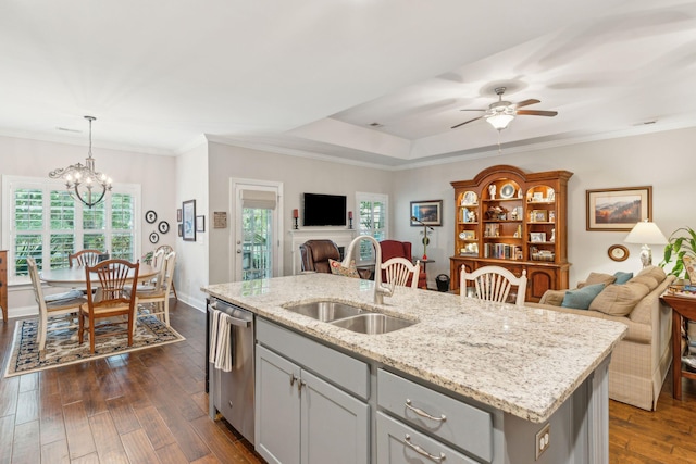 kitchen featuring sink, dark wood-type flooring, hanging light fixtures, stainless steel dishwasher, and a kitchen island with sink