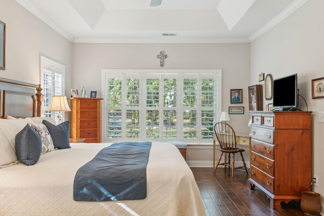 bedroom featuring dark hardwood / wood-style floors, ceiling fan, a raised ceiling, and ornamental molding