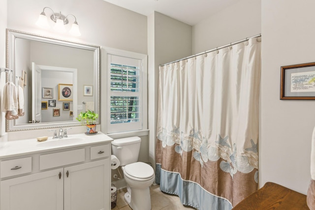 bathroom with tile patterned floors, vanity, toilet, and walk in shower