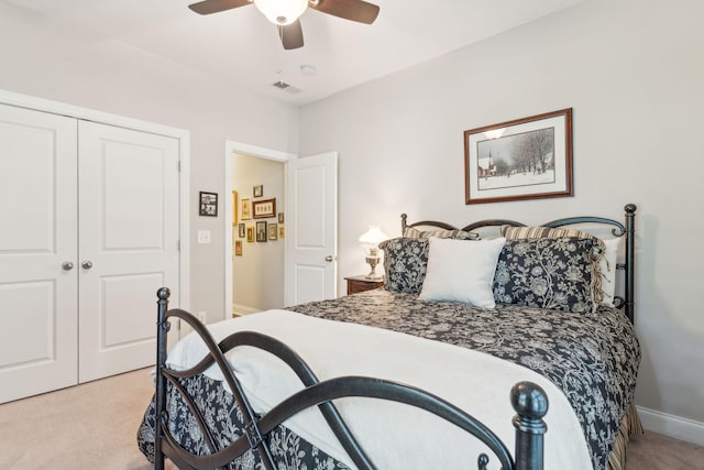 carpeted bedroom featuring ceiling fan and a closet