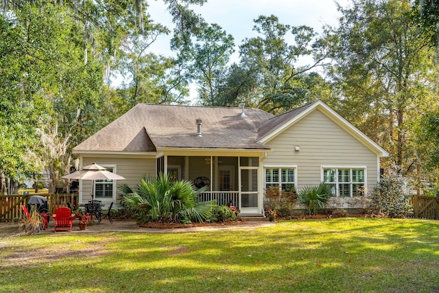 rear view of property with a sunroom, a yard, and a patio